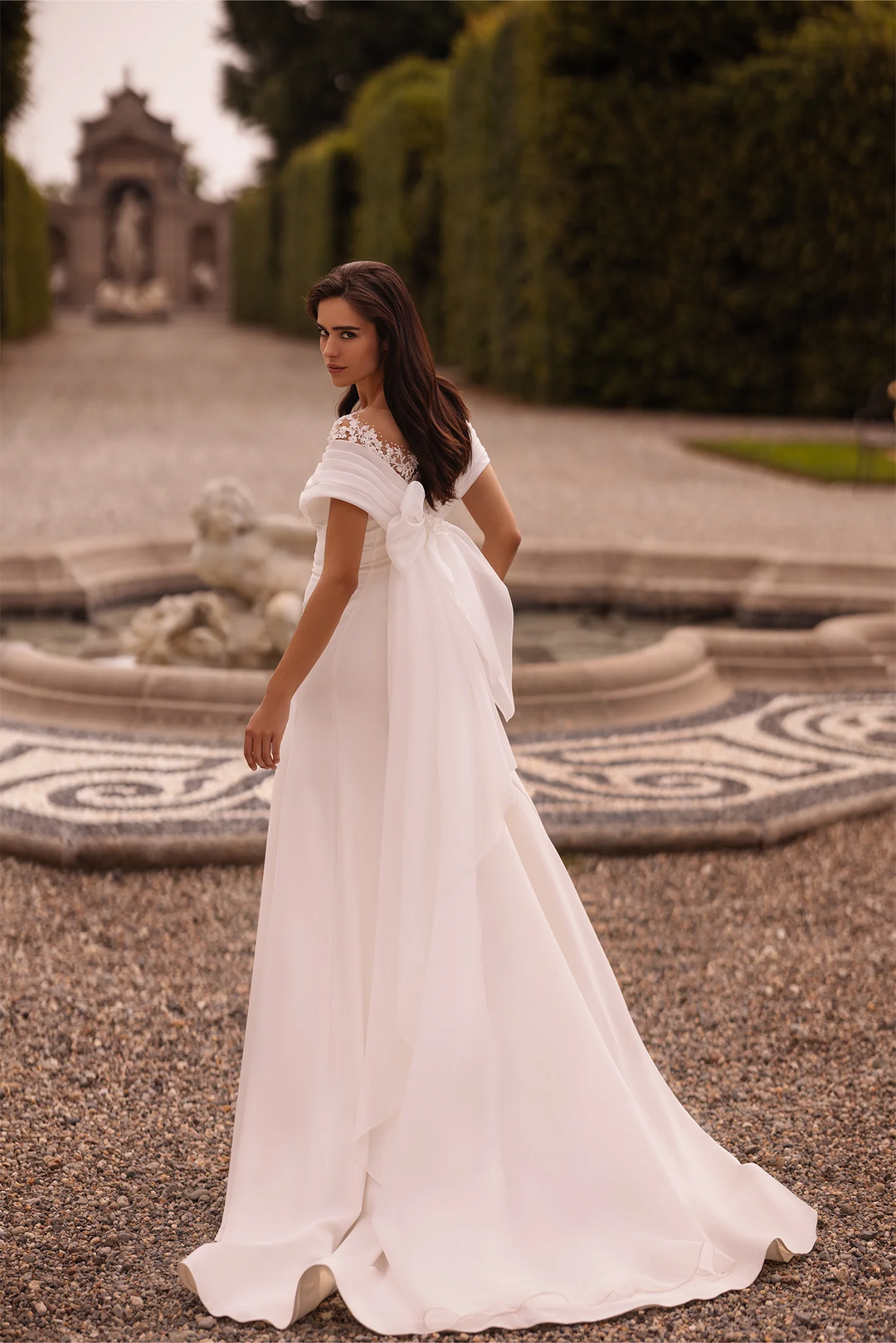 Ivory Off-the-Shoulder Wedding Dress with Thigh Slit – Trumpet Gown with Flower Adorned Neckline and Cascading Bow Plus Size