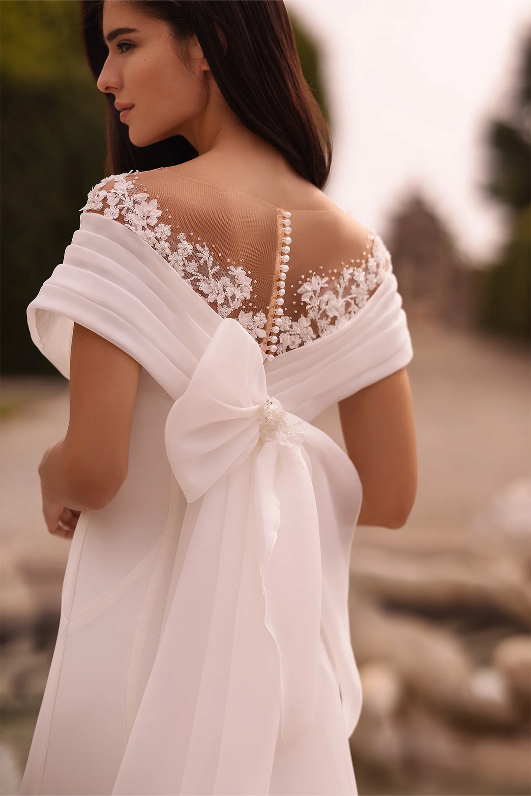 Ivory Off-the-Shoulder Wedding Dress with Thigh Slit – Trumpet Gown with Flower Adorned Neckline and Cascading Bow Plus Size