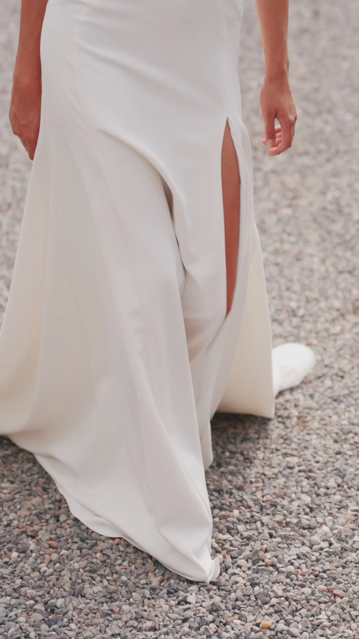 Ivory Off-the-Shoulder Wedding Dress with Thigh Slit – Trumpet Gown with Flower Adorned Neckline and Cascading Bow Plus Size